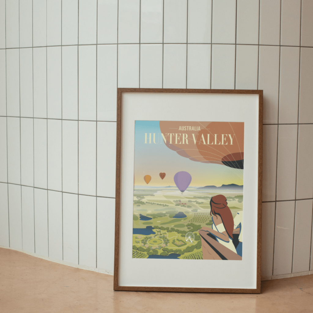Framed Hunter Valley Balloon Sunrise Poster displayed against a modern tiled wall, showcasing an artistic view of hot air balloons floating over the scenic vineyards of Hunter Valley.