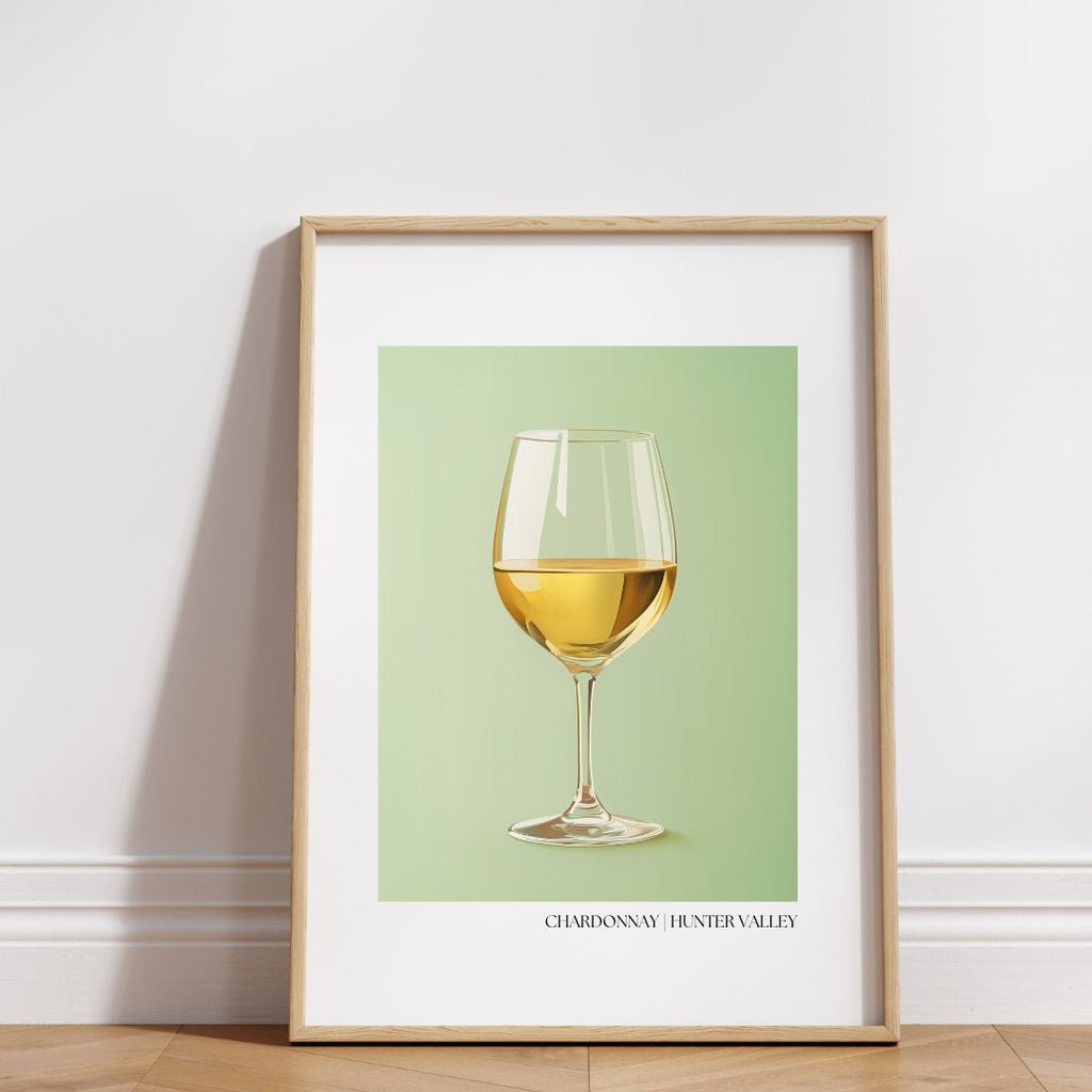 Framed poster of a glass of golden Chardonnay wine set against a soft sage green background. 