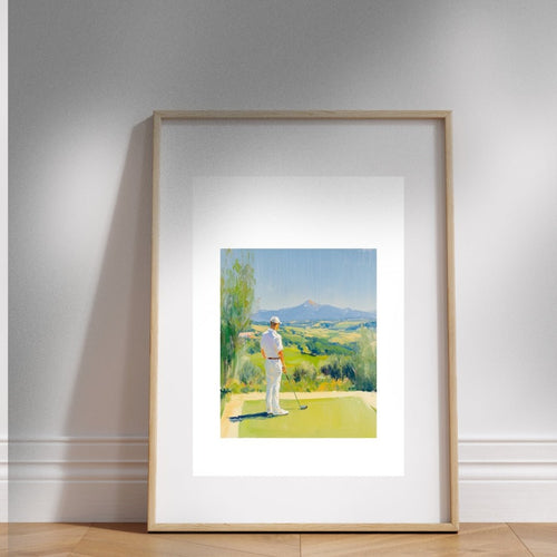Framed artwork of a golfer on a golf course with mountains in the background, displayed on a wall.