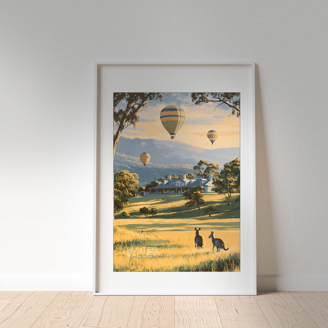 Framed artwork of kangaroos in a field with hot air balloons, on a white wall.