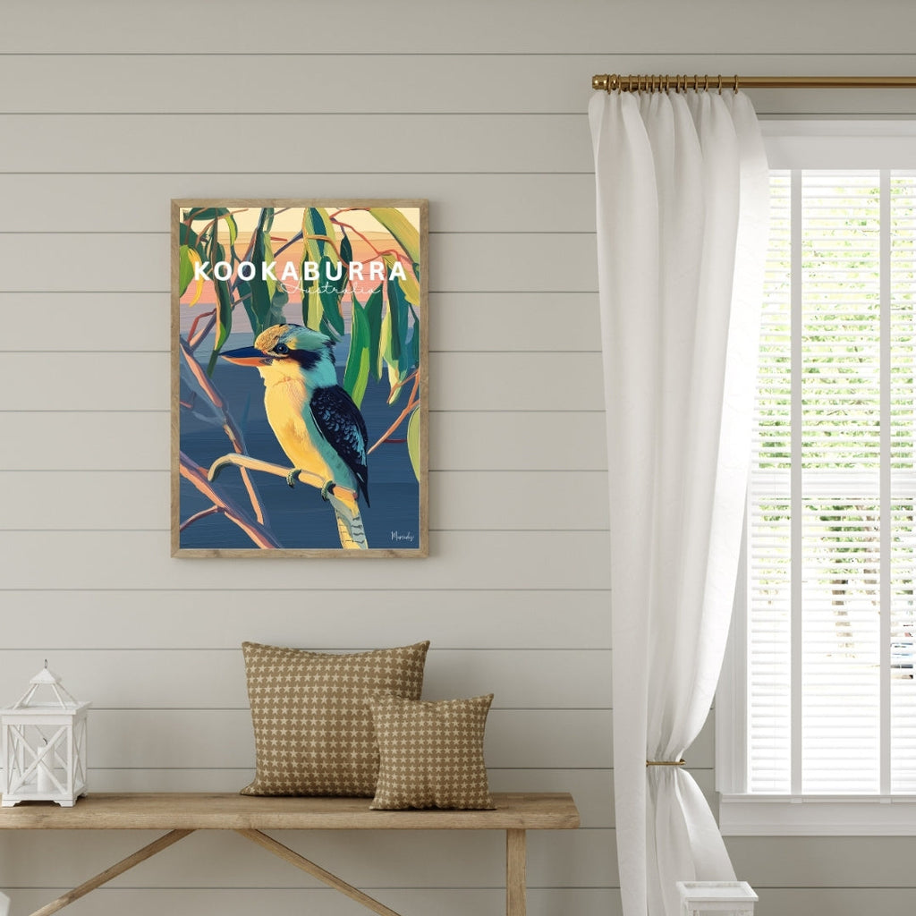 Decorative wall art of a bird with 'Kookaburra' text in a room with a wooden bench and white curtains.