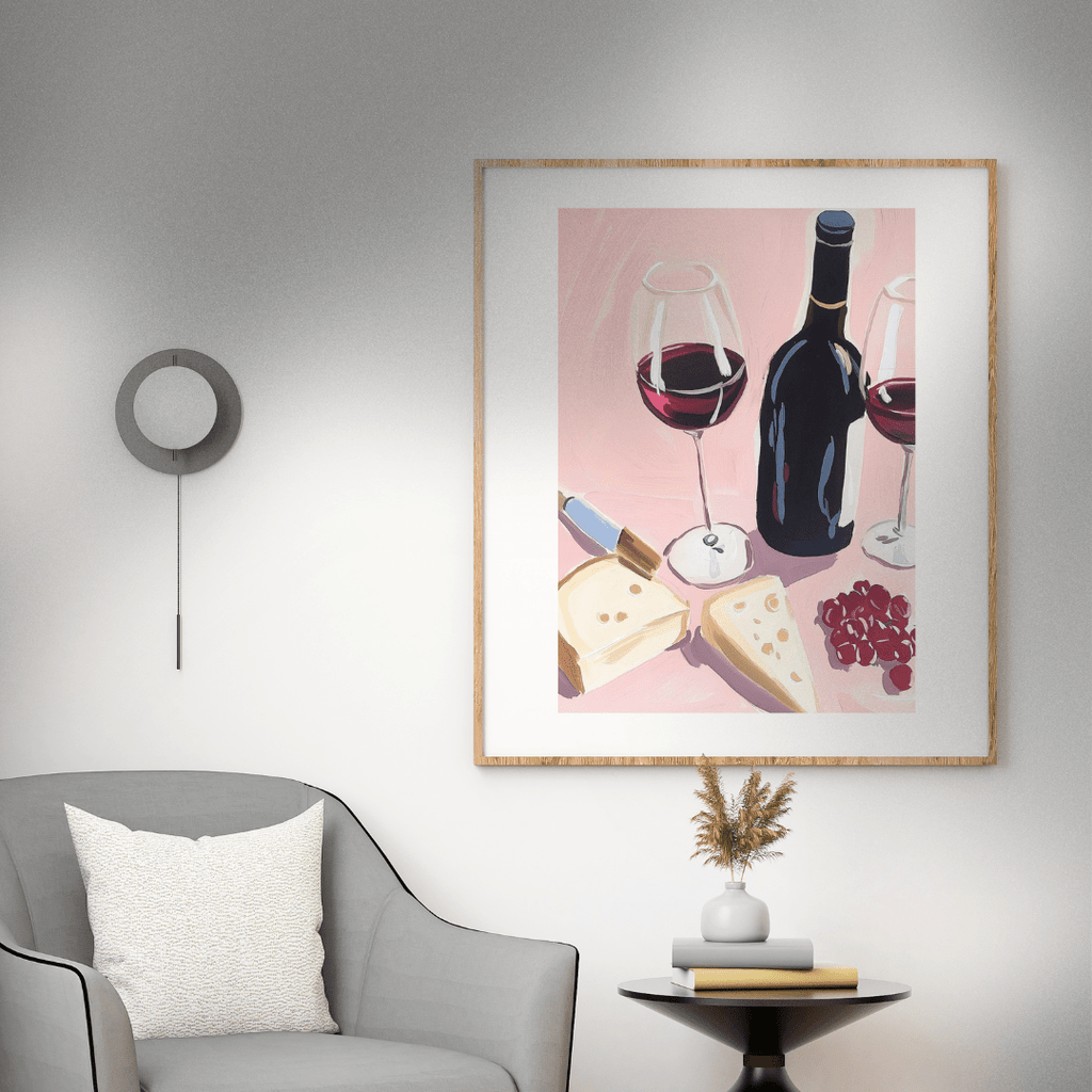 Framed artwork of wine and cheese on a wall above a gray armchair.