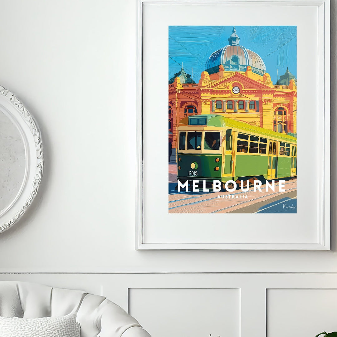 Framed artwork of a Melbourne tram on a wall above a white sofa.