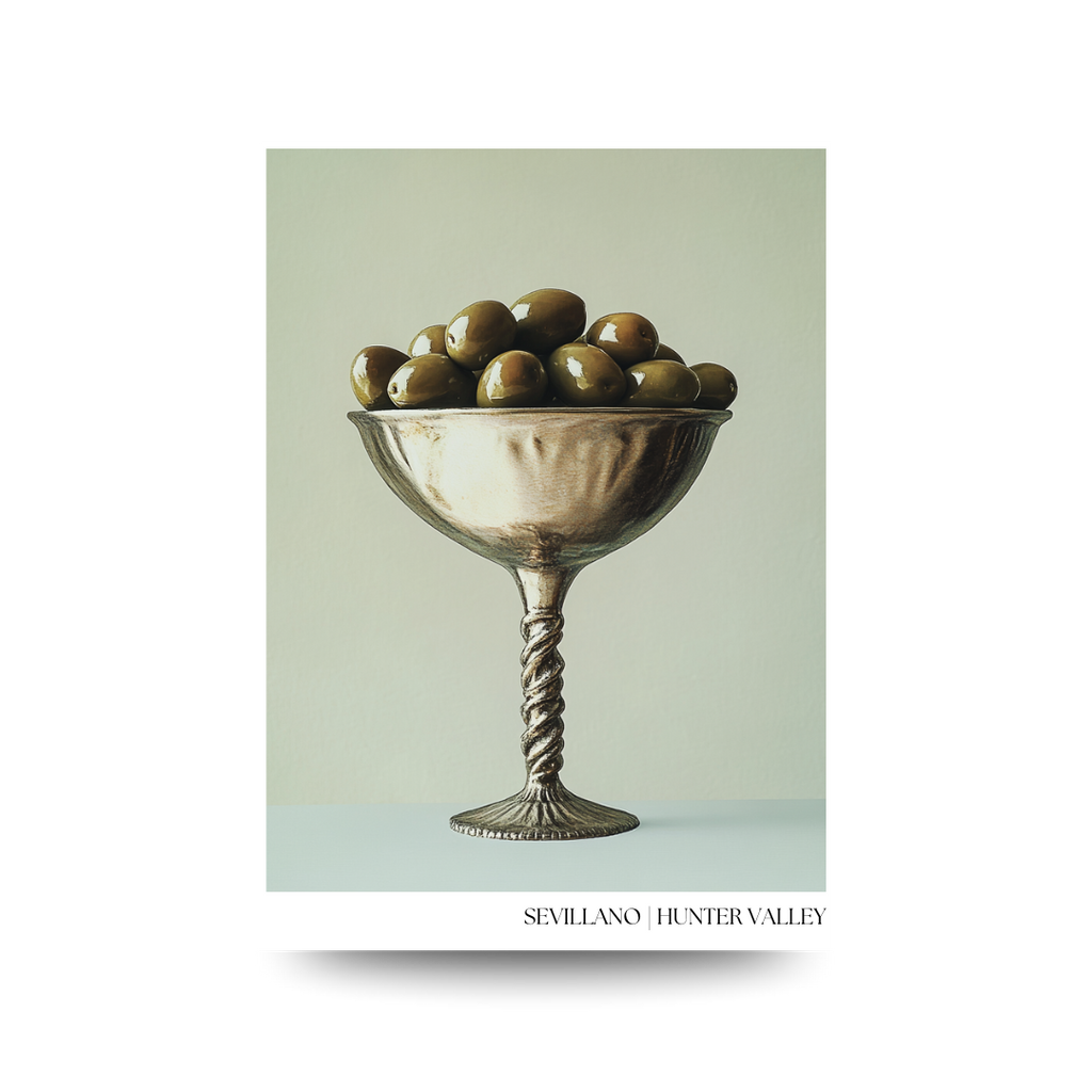 Decorative poster with a silver bowl filled with green olives on a light green background, featuring the brand 'Sevillano Hunter Valley'.
