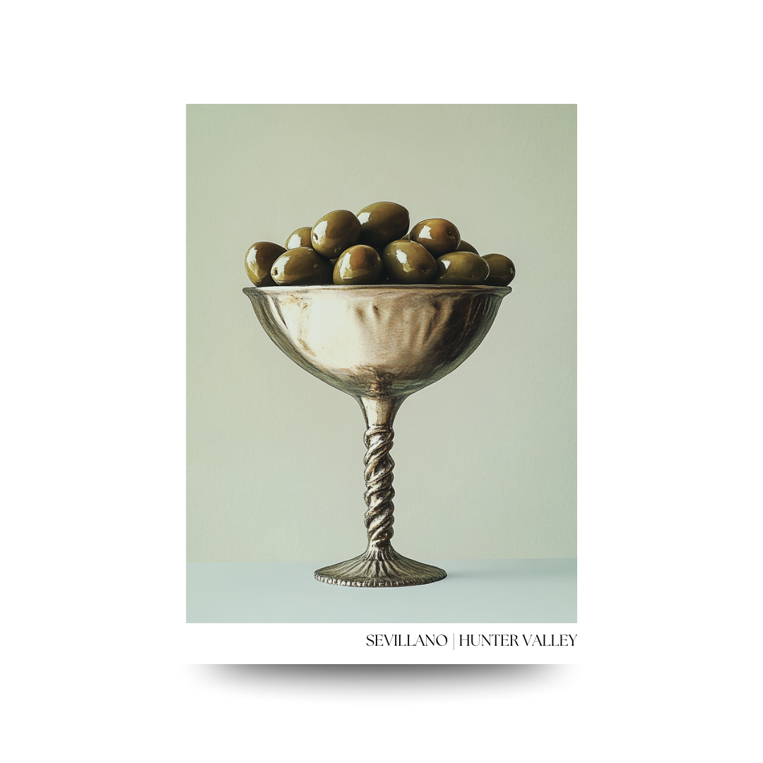 Decorative poster with a silver bowl filled with green olives on a light green background, featuring the brand 'Sevillano Hunter Valley'.